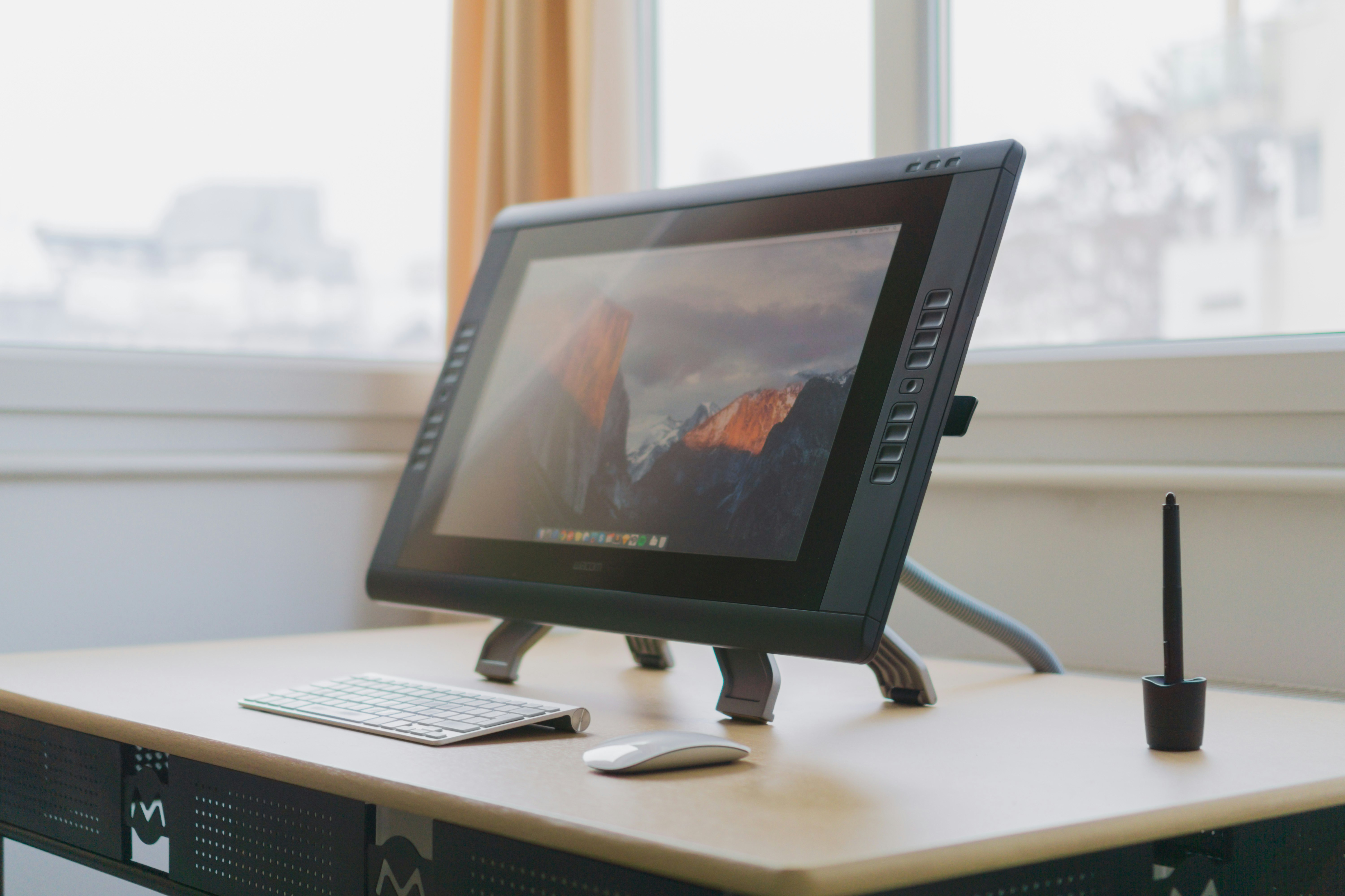 turned on gray flat screen monitor on wooden desk